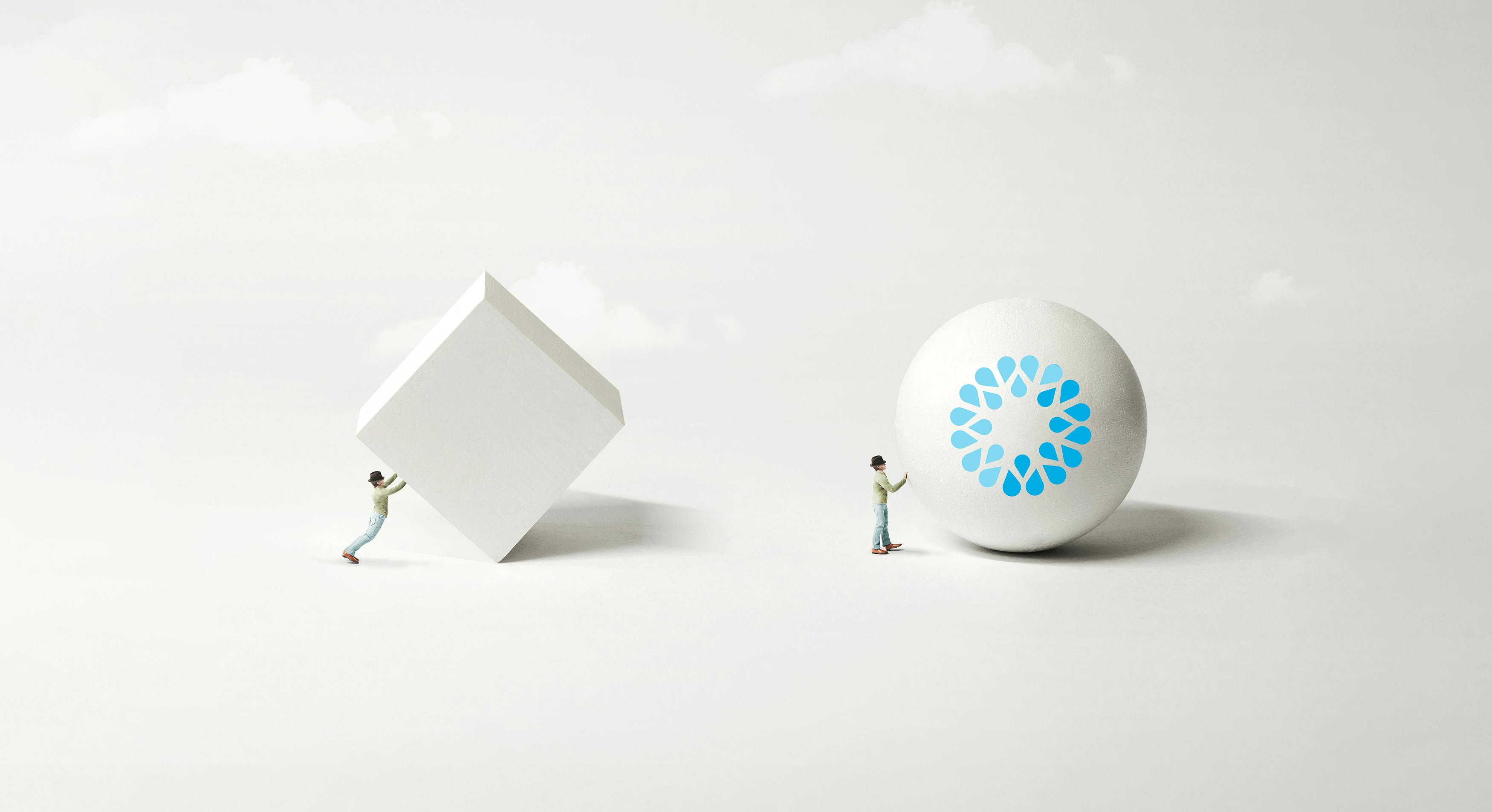 Advance faster with VOSS AI powered automation - image shows person easily rolling a VOSS ball along, while another person behind tries to push a cube with difficulty