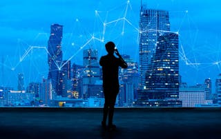 Building an agile digital workplace for an AI world - showing silhouette of a business man on mobile overlooking a network overlayed across a skyline