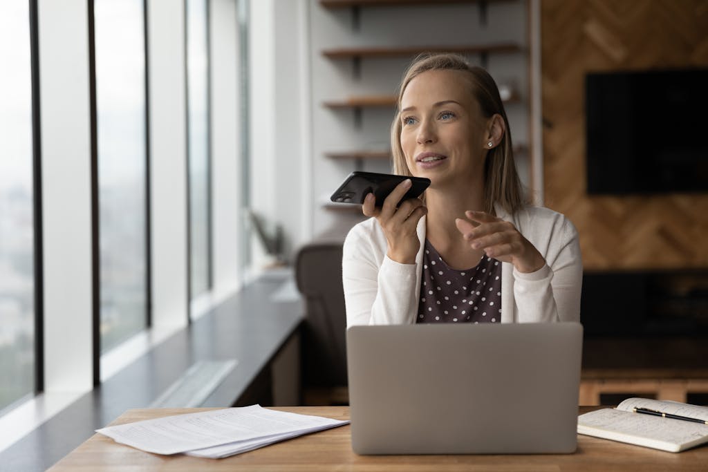 Image of business woman at desk talking into her mobile phone