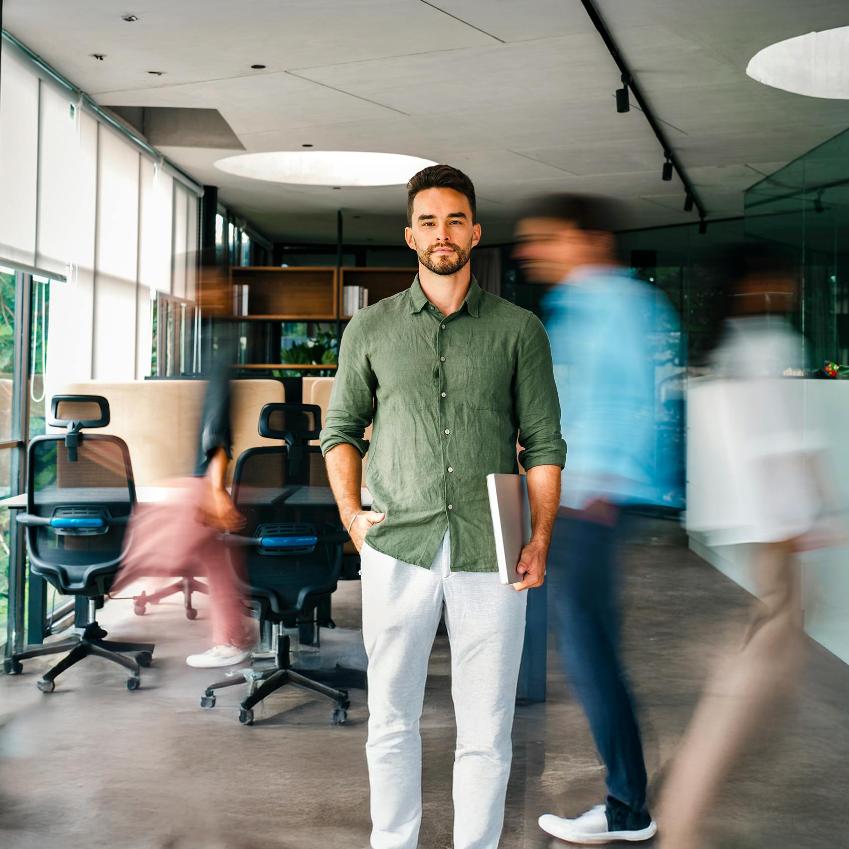 Businessman standing still in office, while people rushing around behind him - Your digital workplace is growing - but your control isn’t blog cover
