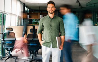 Businessman standing still in office, while people rushing around behind him - Your digital workplace is growing - but your control isn’t blog cover