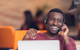 Cisco Prime Collaboration replacement - Happy man using headset with laptop at desk