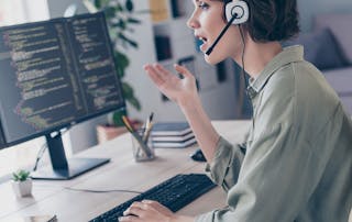 Image of woman talking on headset looking at monitors - The hidden cost of Microsoft Teams calling issues - How proactive monitoring changes the equation blog article
