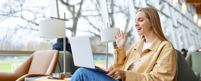Young woman having a meeting in a public area on a laptop - multi-vendor hybrid office meeting room experience