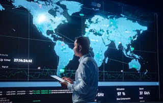 Security by design blog: Project Manager Walks to a Big Screen with Global Map. He is Using a Tablet. Team of Professional Computer Data Science Engineers Work in a System Control and Monitoring Telecommunications Office