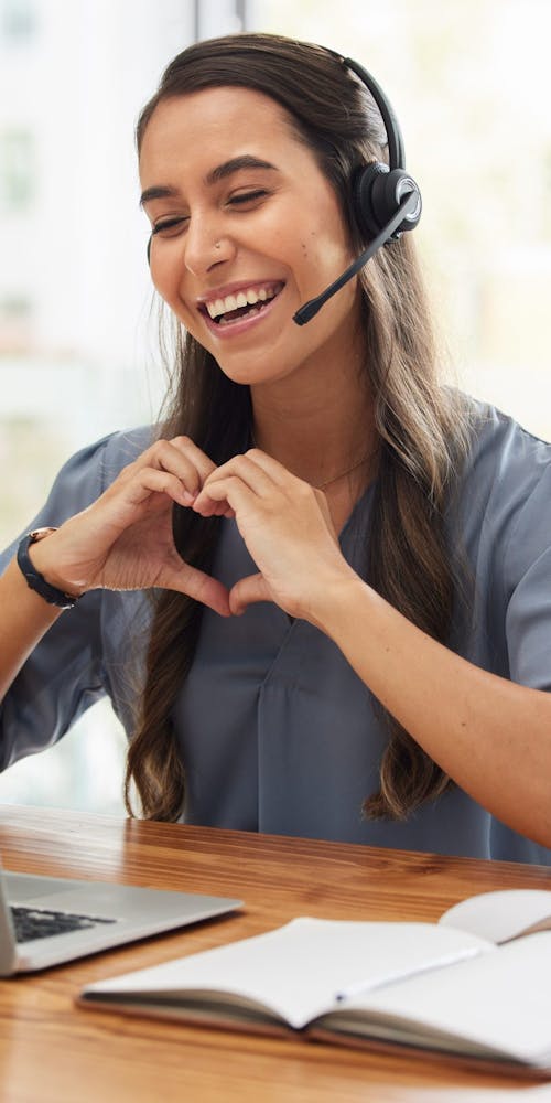 Happy user experience. Woman makes heart shape with hands. VOSS Insights contributes to a seamless and high-quality user experience across your UC environment.