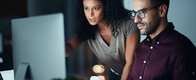 Business people, computer and night team work with planning, collaboration or problem solving at tech company. Developer, programmer and leader with serious for software support and web solution