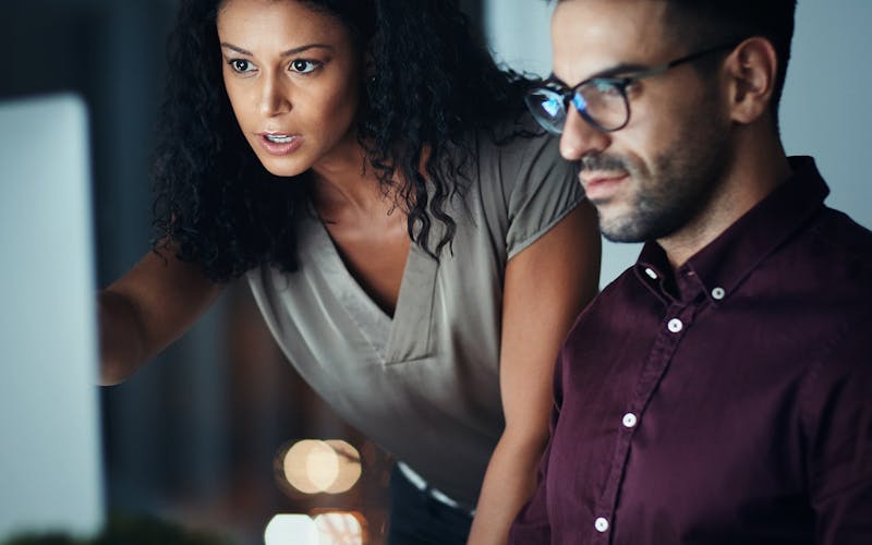 Woman and man having meeting looking at laptop
